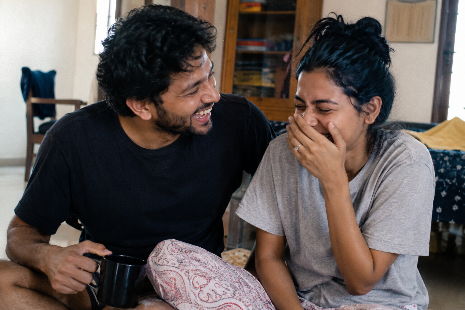 Couple laughing hard together in a bright room