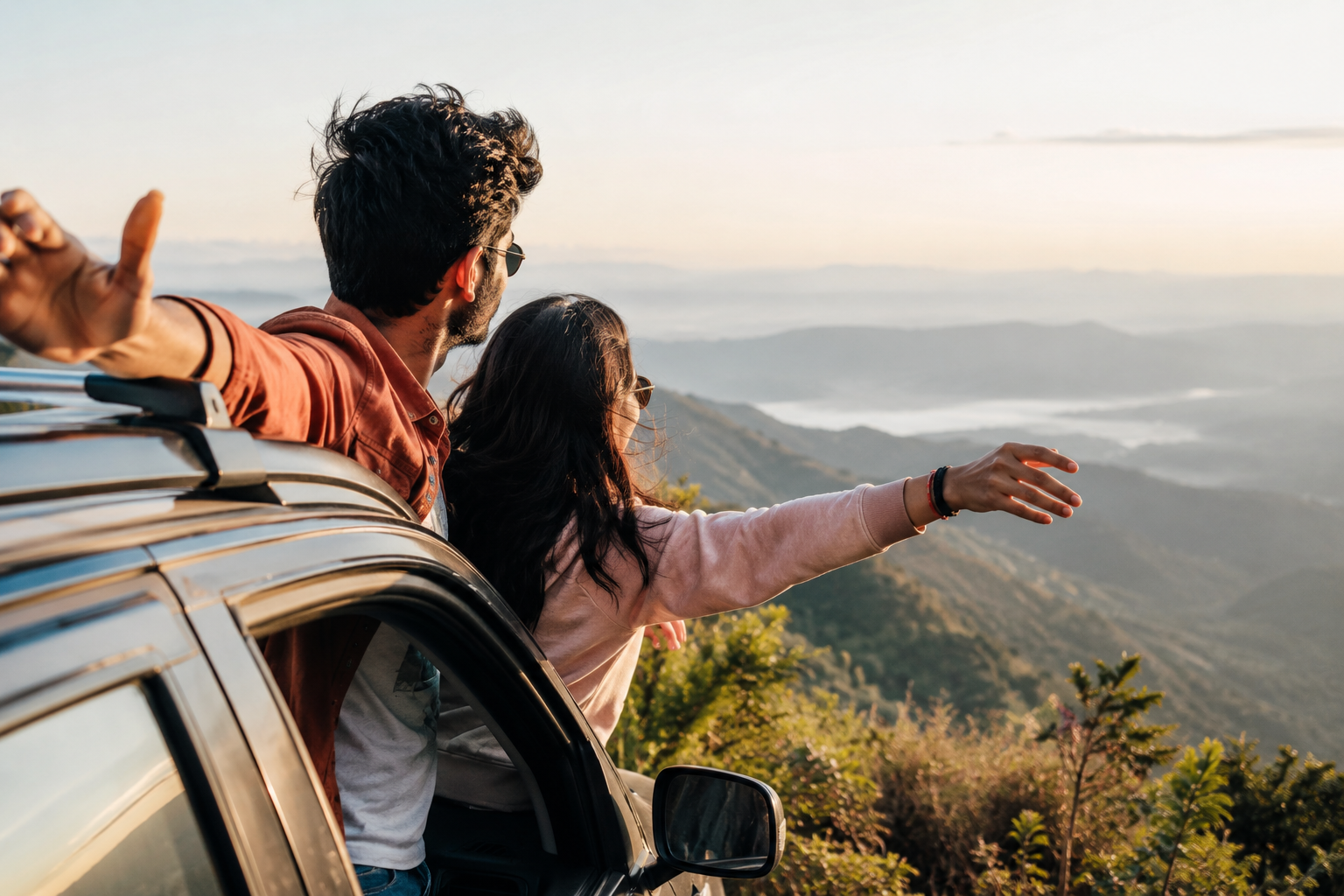 A couple on a road trip or hill viewpoint looking at a landscape